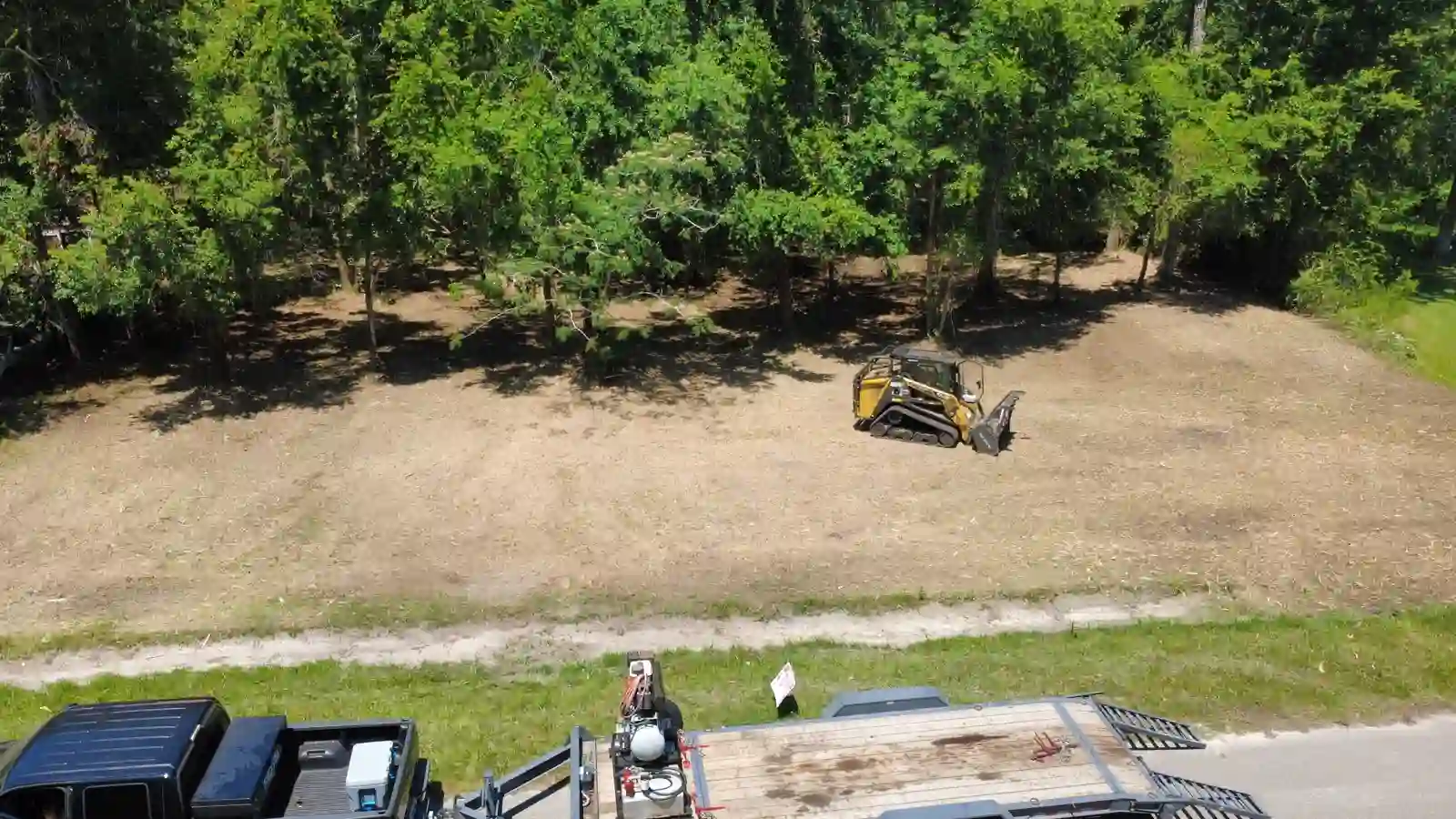 Aerial of cleared Columbia County lot after forestry mulching, truck and trailer on the road